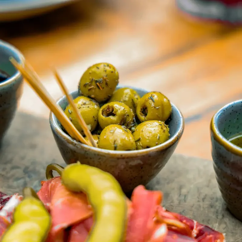 Olives and savoury accompaniments for charcuterie cart styling