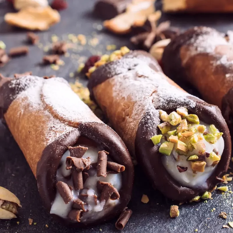 Close-up of fresh cannoli with ricotta filling, chocolate and pistachio toppings